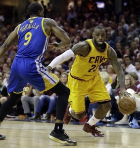 Cleveland Cavaliers forward LeBron James (23) drives on Golden State Warriors guard Andre Iguodala (9) during the first half of Game 4 of basketball's NBA Finals in Cleveland, Thursday, June 11, 2015. (AP Photo/Tony Dejak)